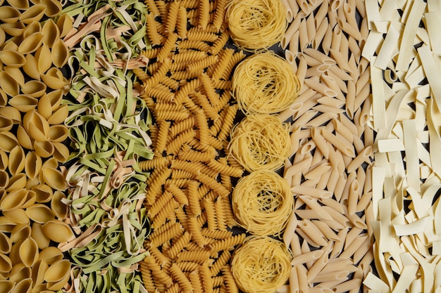 Variety of types and shapes of dry Italian pasta. Italian Macaroni raw food: pasta, spaghetti , pasta in shape of spiral.