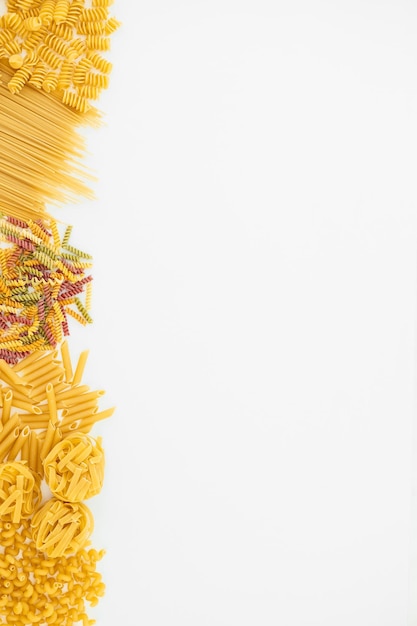 Variety of types and shapes of Italian pasta on white background