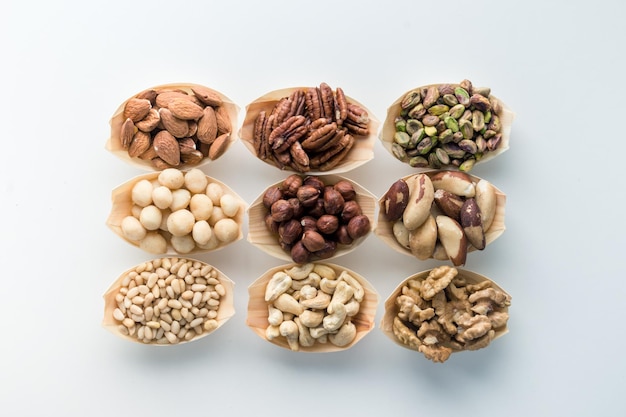 variety of useful nuts in wooden bowls on a white background