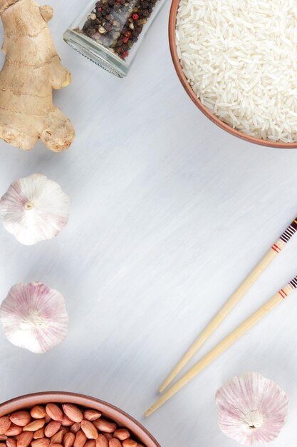 Various asian vegetarian cooking ingredients Rice peanuts and spices on white background Top view Copy space