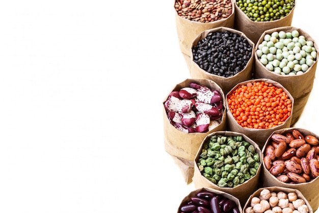 Various assortment set of indian legumes in paper sack bags isolated on white background.