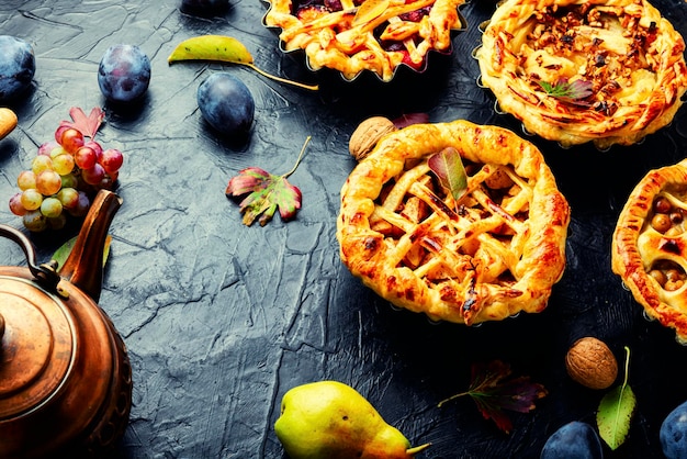 Various autumn pies with pear, apple, grapes and plum.Autumn homemade confectionery