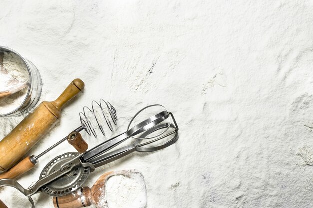 Photo various baking tools on flour.