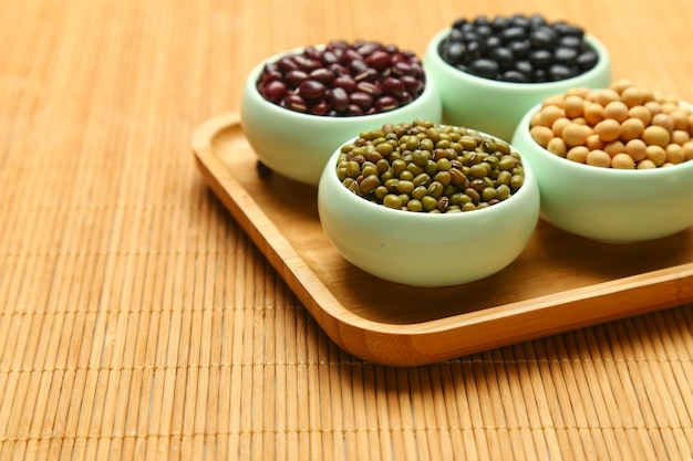 various beans in cups on bamboo