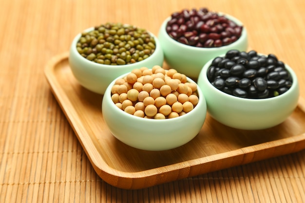 various beans in cups on bamboo