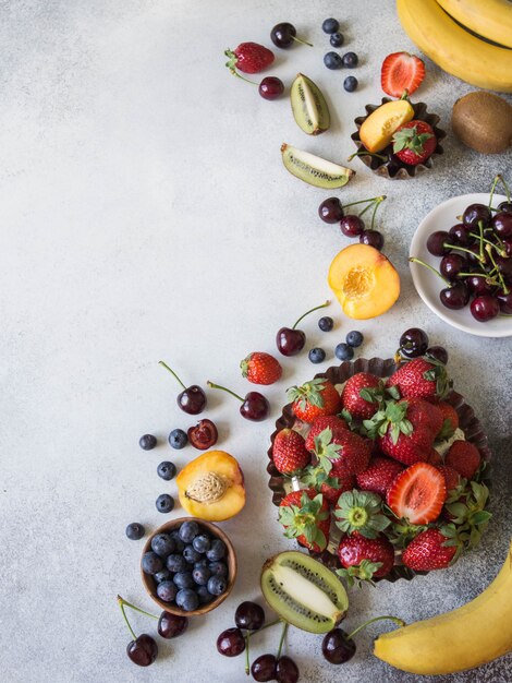 Various berries and fruits on a gray background