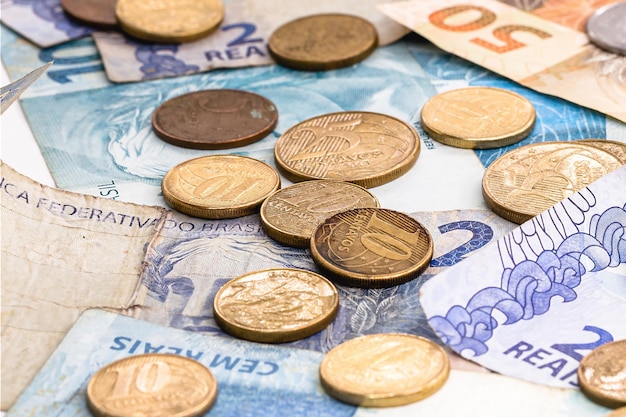 写真 さまざまなブラジルの紙幣さまざまな価値の硬貨が汚れて床に横たわっている混乱した金融または金融危機のコンセプト