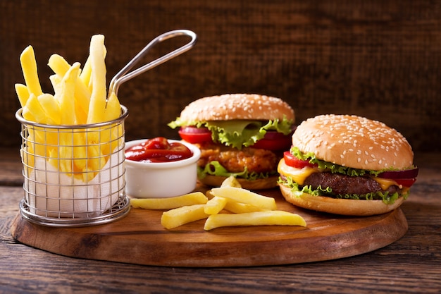 Various burgers with french fries on a wooden table