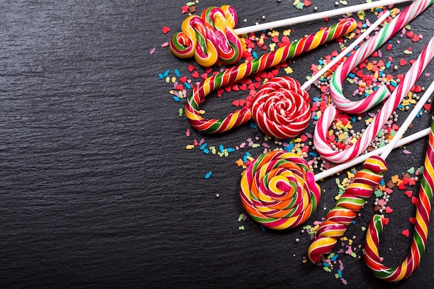 Various candy canes on dark background, top view with copy space