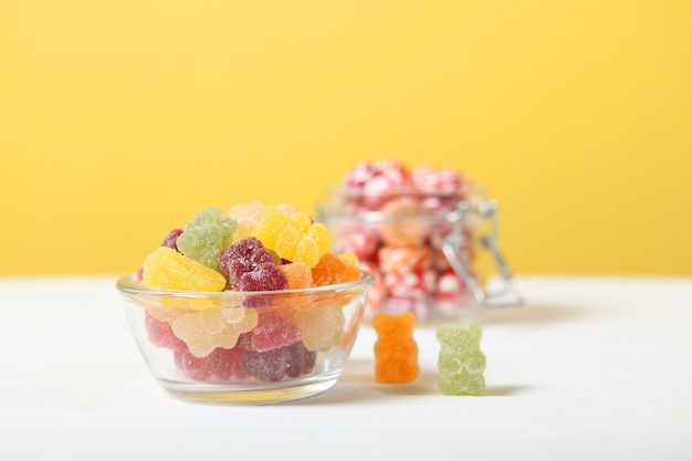 Various candy and sweets on the table on a colored background