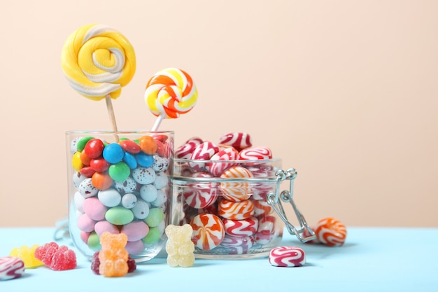 Various candy and sweets on the table on a colored background