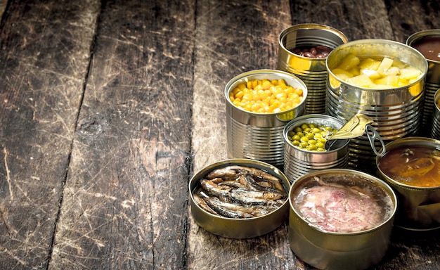 Various canned vegetables, meat, fish and fruits in tin cans. 