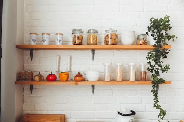 Various cereals in glass jars placed on wooden shelves in the kitchen pasta and cereals