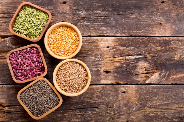 Various cereals, seeds, beans and grains on wooden table