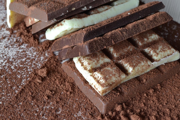코코아 가루의 다양한 초콜릿이 흰색 테이블에 흩어져 있습니다.