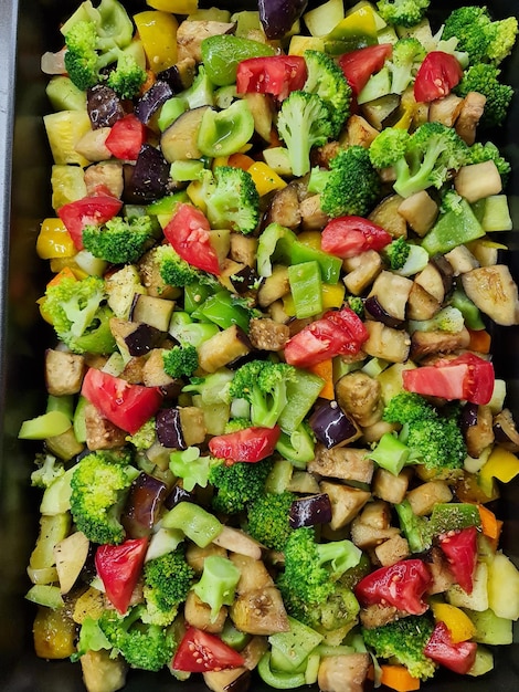 Various chopped stewed vegetables on a black surface.