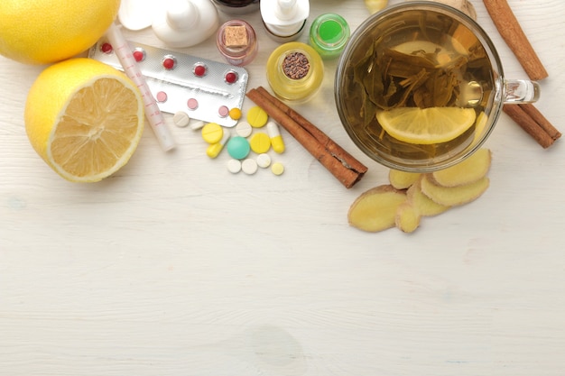 Различные лекарства от простуды и средства от простуды на белом деревянном столе.