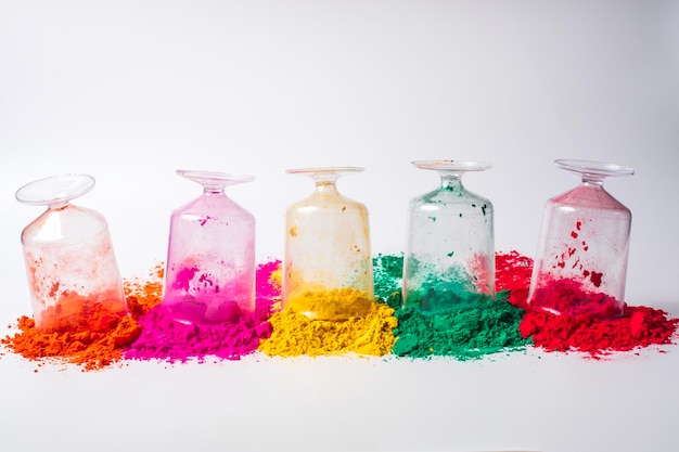 Various colorful holi powder in glass bottles isolated on white background