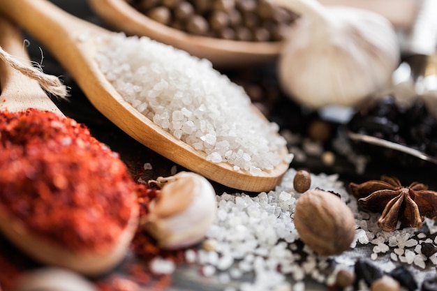 Various colorful spices in wooden spoons