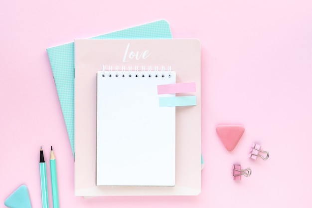 Various colorful stationery for school and office on pink with copyspace