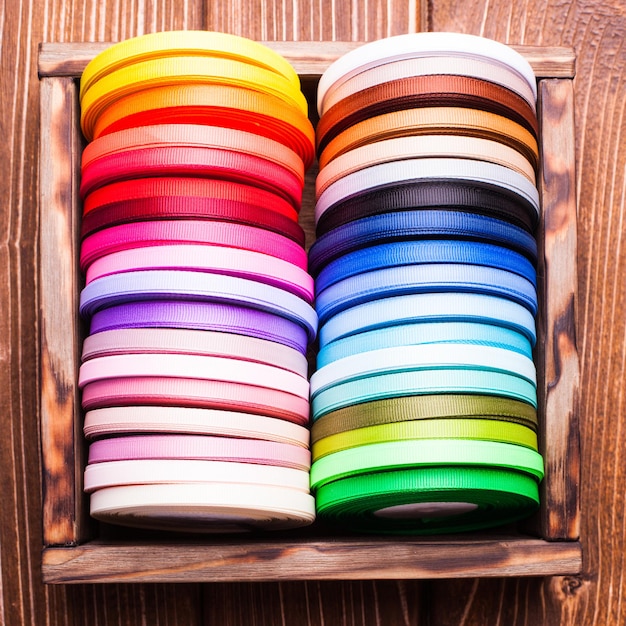 Various colors ribbon bobbins in vintage wooden box