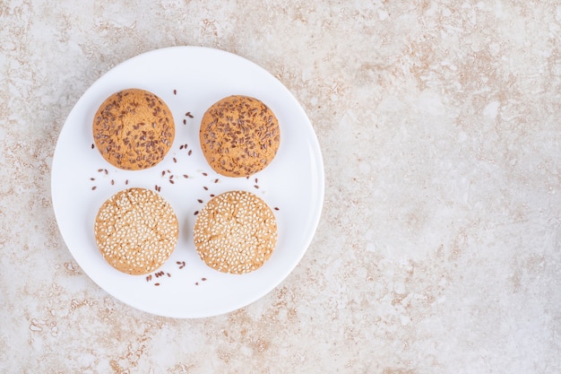 Photo various cookies on a plate, on the marble.