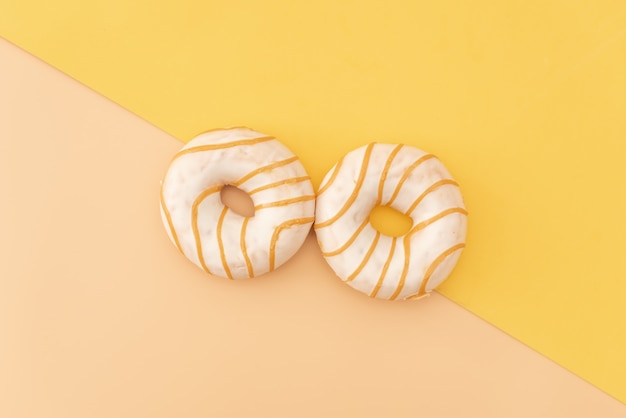 Various decorated doughnuts in motion falling on pink background. Sweet and colourful doughnuts falling or flying in motion. 