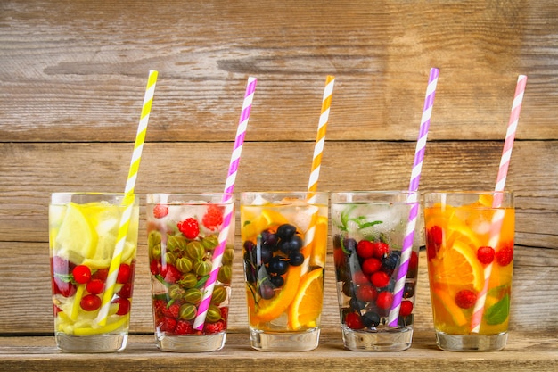 Various detox water in glasses, different tastes, berries, fruits.