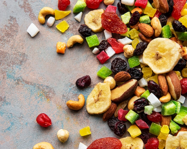 Photo various dried fruits and mix nuts on a gray concrete surface