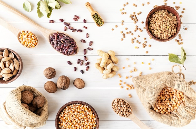 Various dried legumes top view flat lay on white wooden background