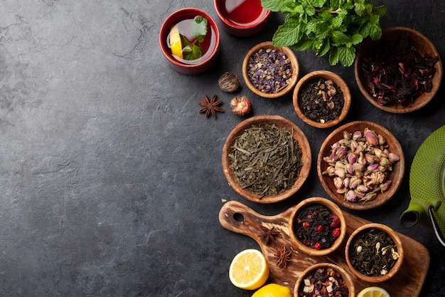 Various dried tea and teapot Top view flat lay with copy space