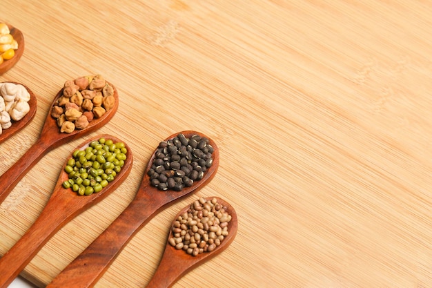 Various dried types of bean and pea in wooden spoon