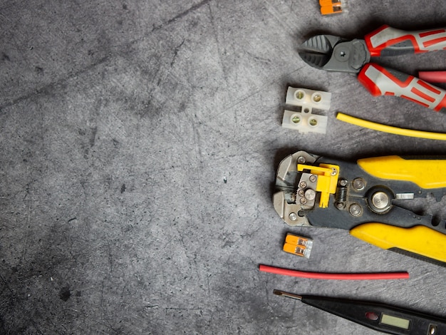 Various electrician tools on gray background with copy space. view from above