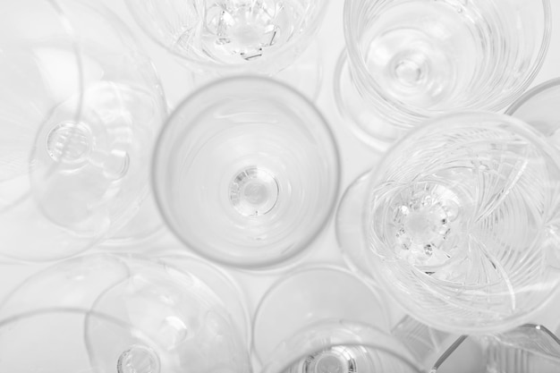 Various empty drink glasses on a white background. Set of empty glasses on white table. Top view