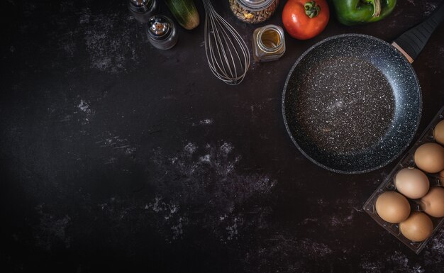 Various food ingredients on a dark background with a space for text or message 