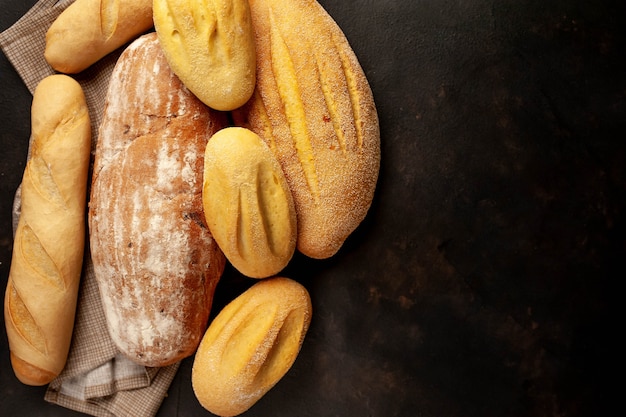 Various fresh bread and buns on a stone table.