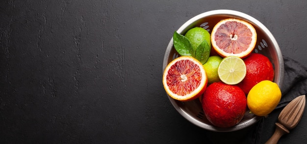 Various fresh citrus fruits in colander Bood orange lime lemon