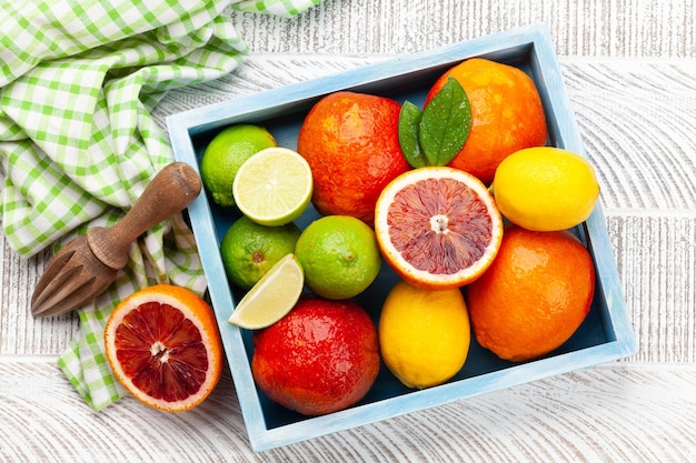 Various fresh citrus fruits in wooden box