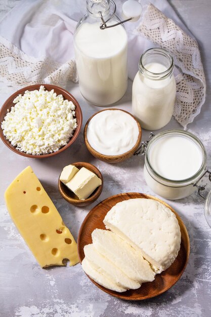 Various fresh dairy products milk sour cream cottage cheese yogurt and butter on a light stone countertop