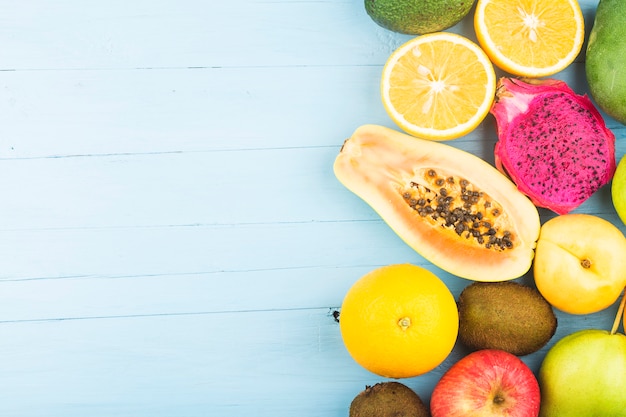 Various fresh fruits on top of blue wooden board