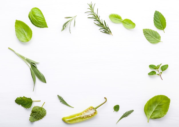 Various fresh herbs for cooking ingrediens on white wooden background with flat lay .