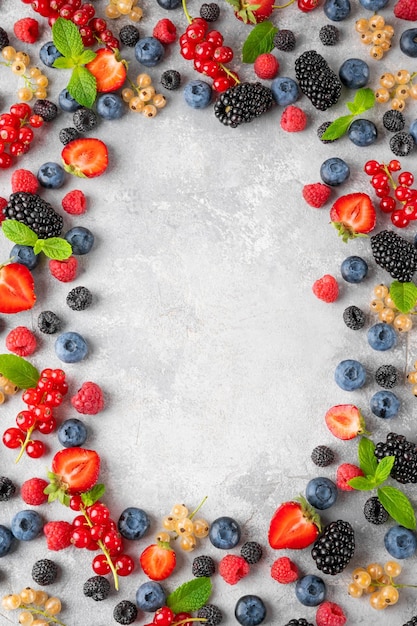 Various fresh summer berries on a gray concrete background Healthy food concept Food background