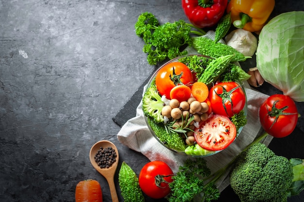 Vari alimenti biologici di verdure fresche per sano su fondo rustico scuro con copia spac