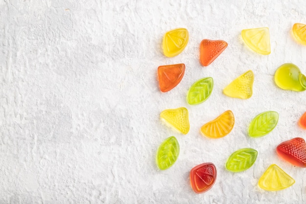 Various fruit jelly candies on gray concrete background