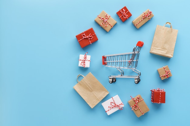 Various gift boxes and bags around a shopping cart
