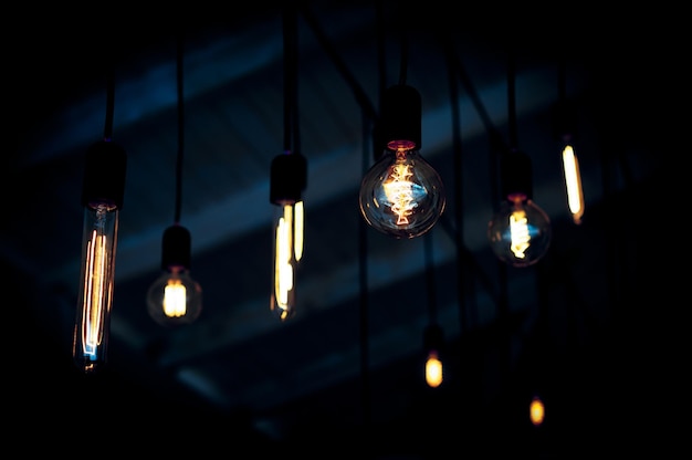 Various glass light bulbs glowing in darkness