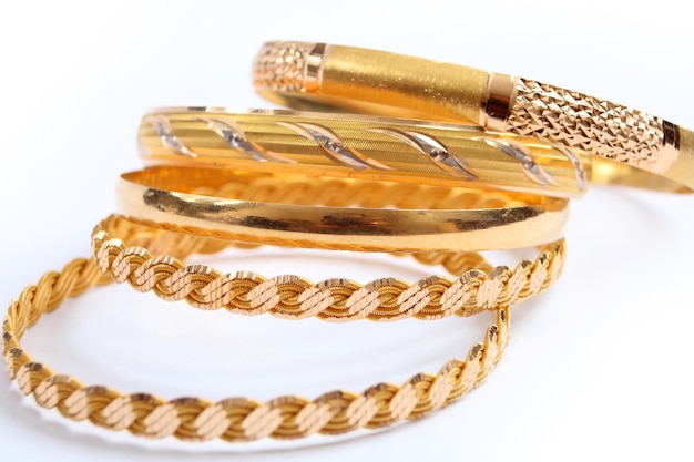 Various gold bracelets on a white background