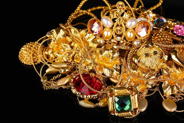 Various gold jewellery on black background