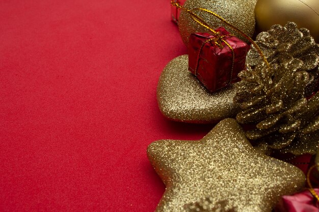 Various golden christmas ornaments on red background