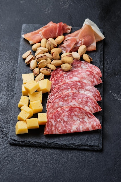 Various gourmet wine snacks. Salami, prosciutto, pistachio, cheese. Italian snacks for an important holiday.